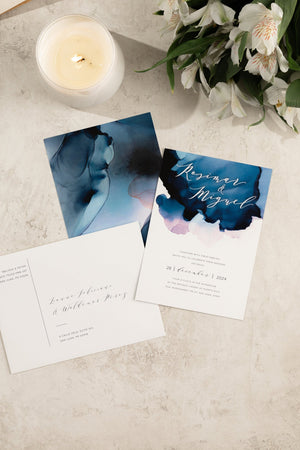 Abstract ocean-inspired watercolor wedding invitation and printed envelope with customizable ombre watercolor background in soft blues and sea tones.